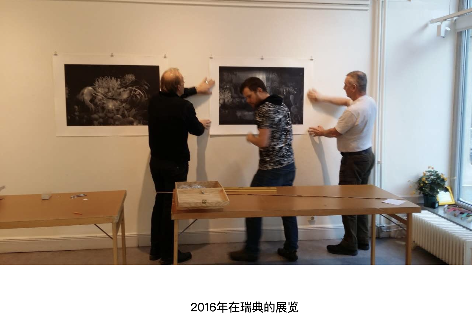 2016 年瑞典展览布展现场，工作人员正在墙面安装作品